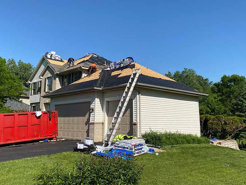 Clear Point Construction, Inc. workers installing new shingles on a home